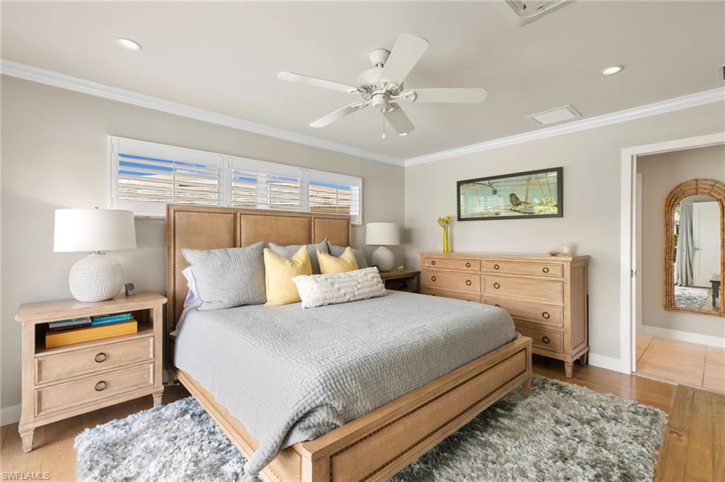 2140 Shad Court Naples, FL 34102 - Photo 38 of 44 a bedroom with a bed and a chandelier