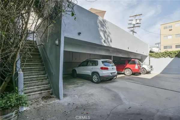 a view of a roof deck with table and chairs under an umbrella with wooden floor