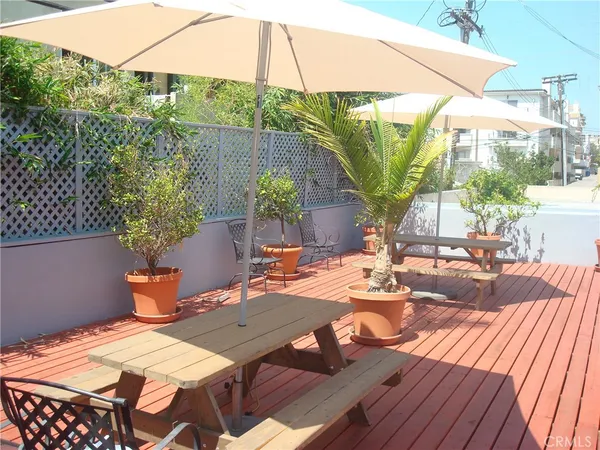 a view of a patio with table and chairs potted plants with wooden floor