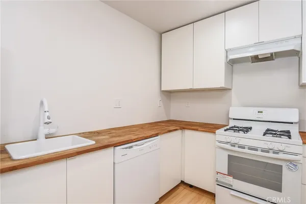 a kitchen with granite countertop white cabinets and white appliances