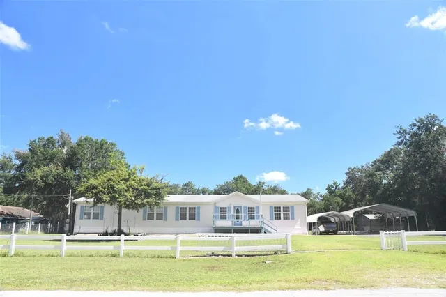 a front view of a house with a garden and trees