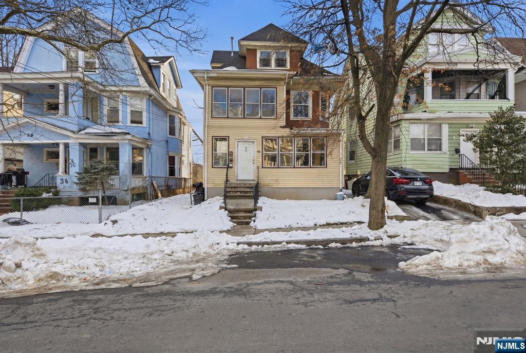 a front view of a house with a yard covered with snow