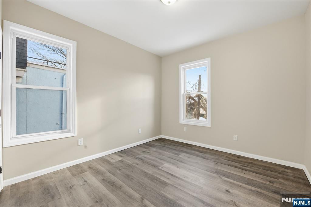38 Mapes Avenue Newark, NJ 07112 - Photo 12 of 27 a view of an empty room with wooden floor and a window