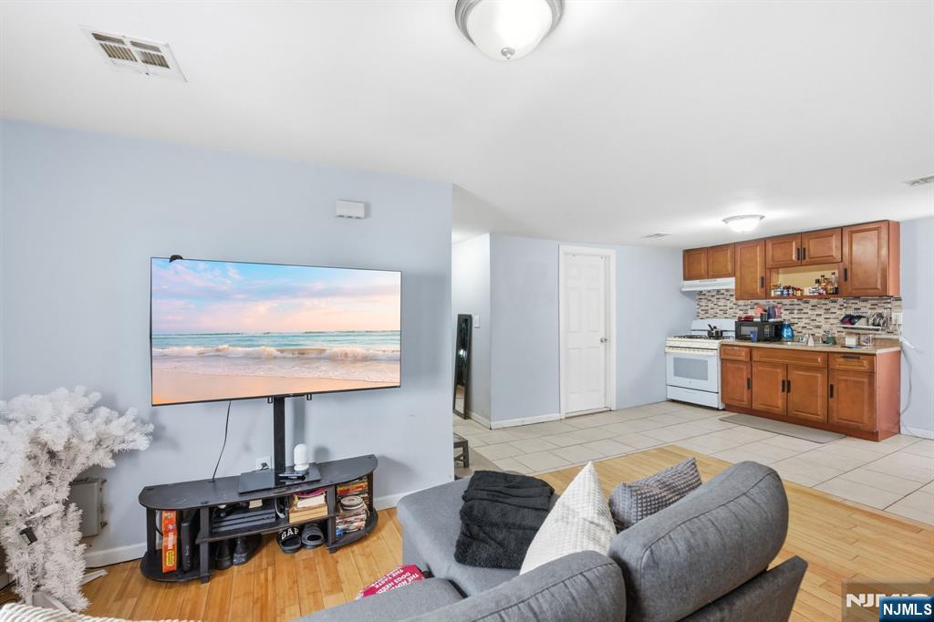 38 Mapes Avenue Newark, NJ 07112 - Photo 18 of 27 a living room with furniture kitchen view and a large mirror