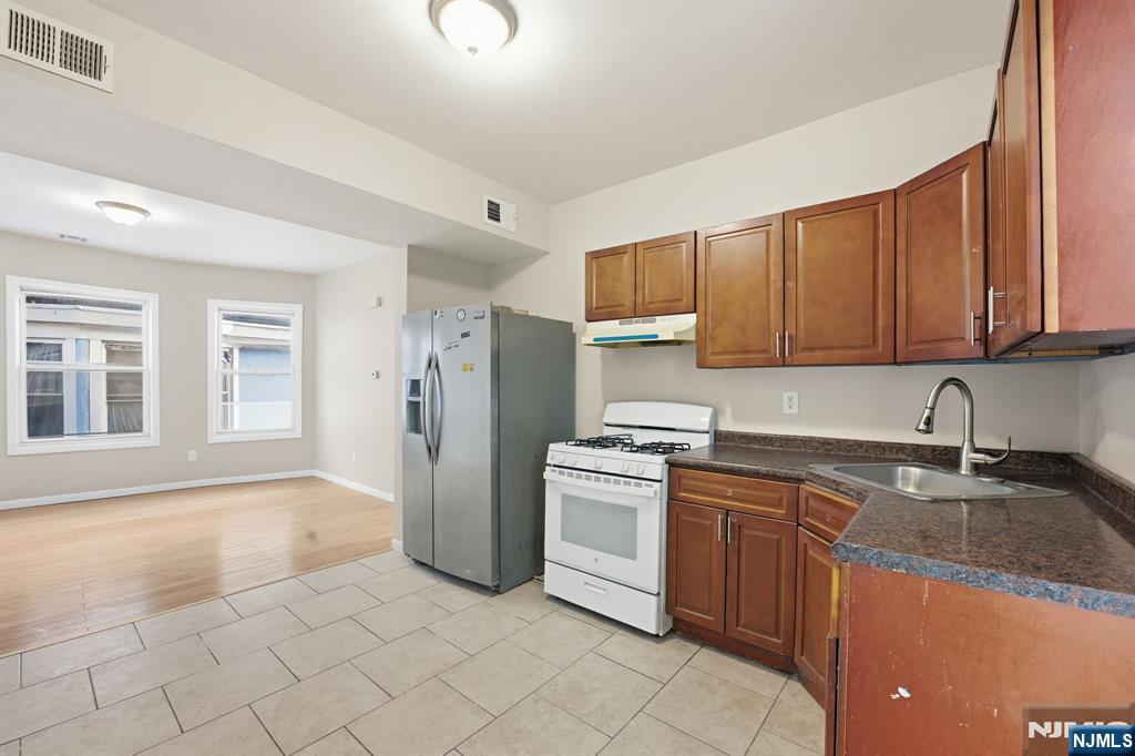 38 Mapes Avenue Newark, NJ 07112 - Photo 24 of 27 a kitchen with stainless steel appliances granite countertop a sink stove and refrigerator