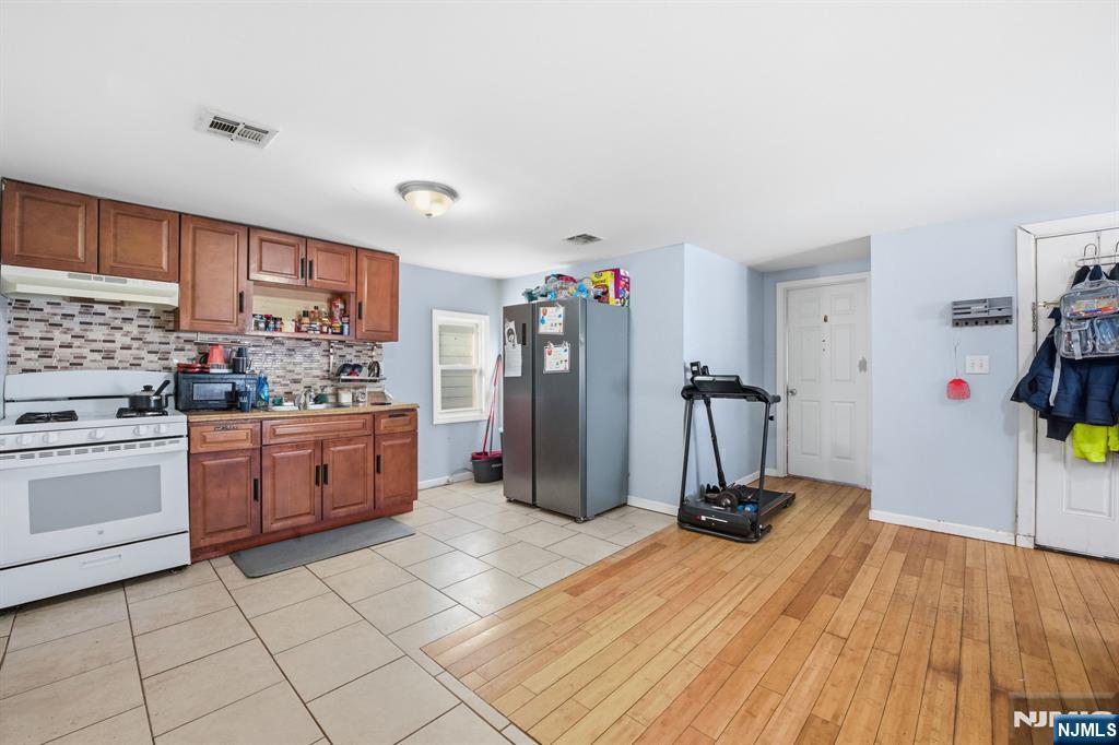 38 Mapes Avenue Newark, NJ 07112 - Photo 26 of 27 a kitchen with a sink a stove and white cabinets