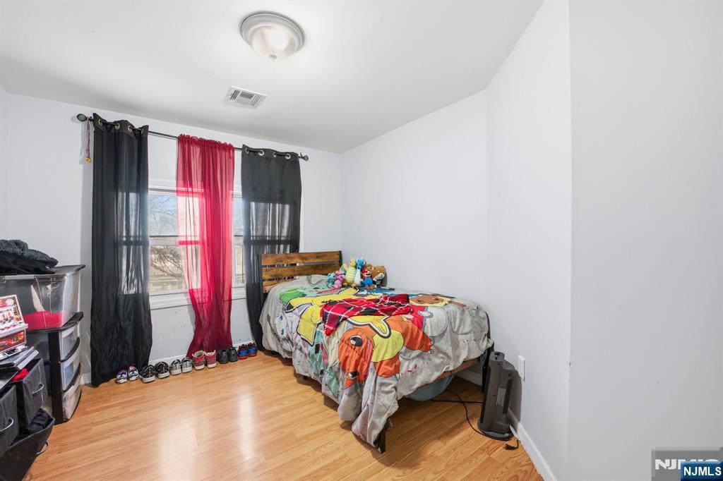 38 Mapes Avenue Newark, NJ 07112 - Photo 27 of 27 a bed sitting in a bedroom next to a window