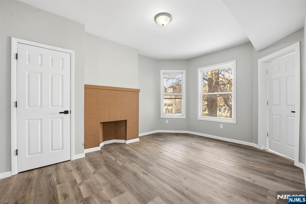 38 Mapes Avenue Newark, NJ 07112 - Photo 5 of 27 an empty room with windows and fireplace