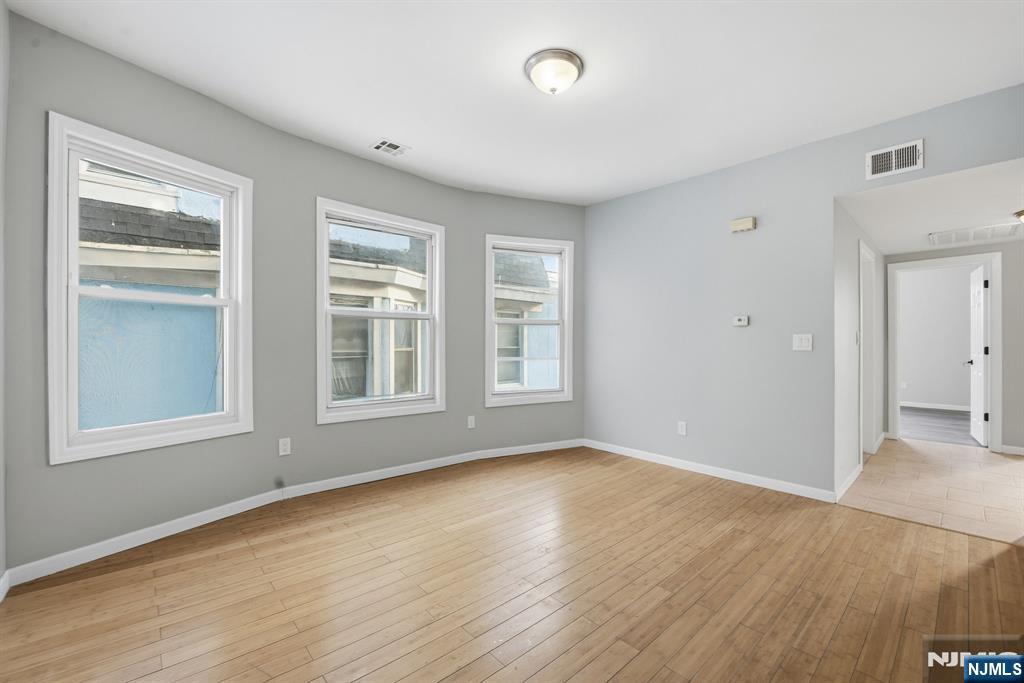 38 Mapes Avenue Newark, NJ 07112 - Photo 9 of 27 a view of an empty room with wooden floor and a window