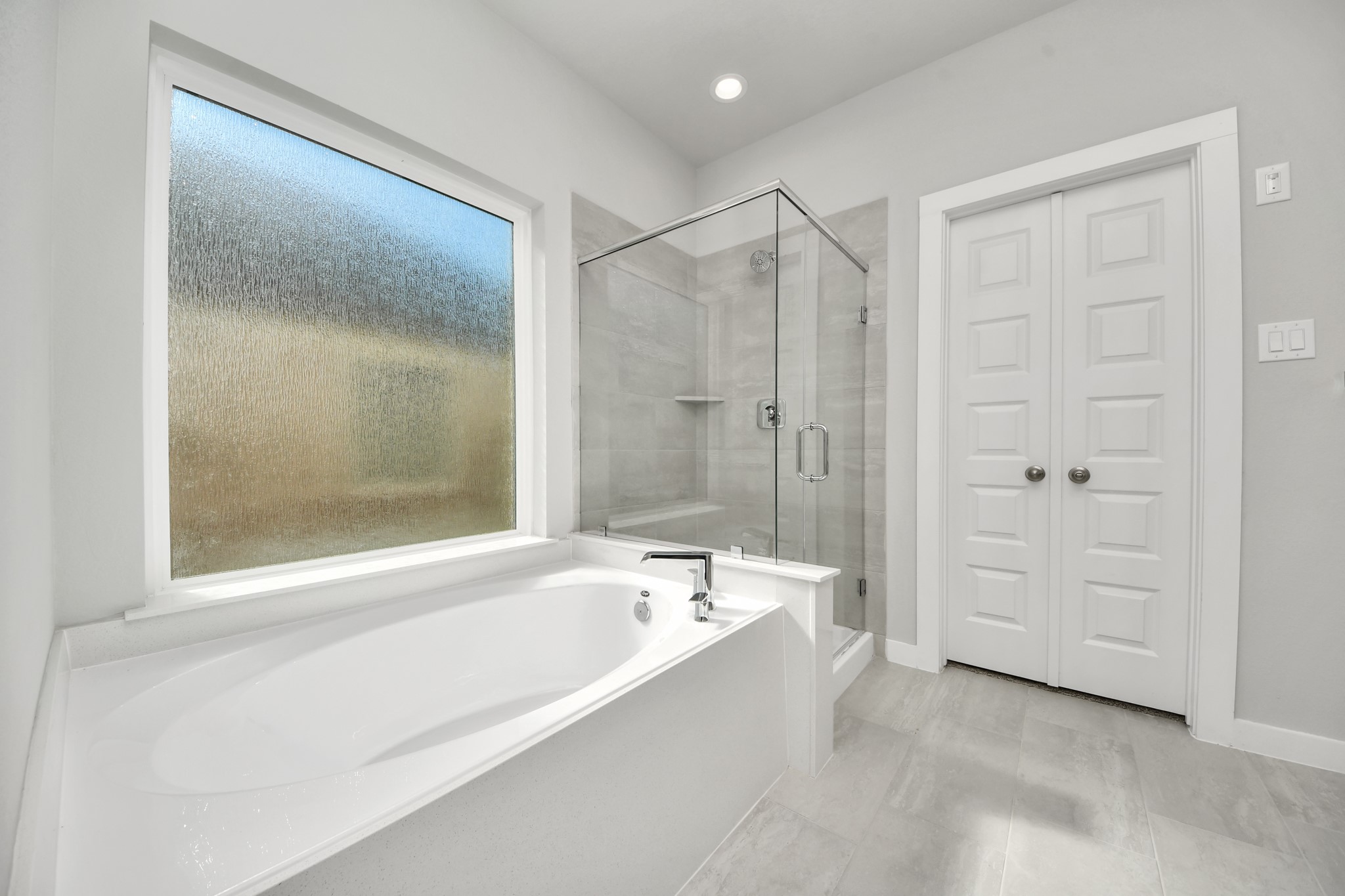 2934 Burris Park Drive Spring, TX 77373 - Photo 23 of 35 Indulge in a spa-like retreat within the confines of this primary bathroom. Delight in a spacious walk-in shower enveloped in stylish tile surround, unwind in a separate garden tub adorned with custom detailing. Sample photo of completed home with similar floor plan. Actual colors and selections may vary.