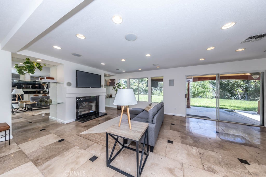 1881 Duncan Way Corona, CA 92881 - Photo 29 of 75 a living room with furniture a fireplace and a floor to ceiling window