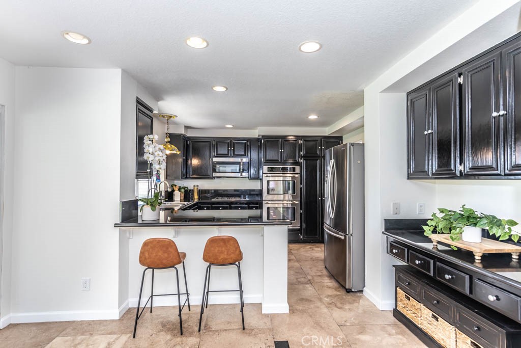 1881 Duncan Way Corona, CA 92881 - Photo 34 of 75 a kitchen with stainless steel appliances kitchen island granite countertop a refrigerator and a stove top oven