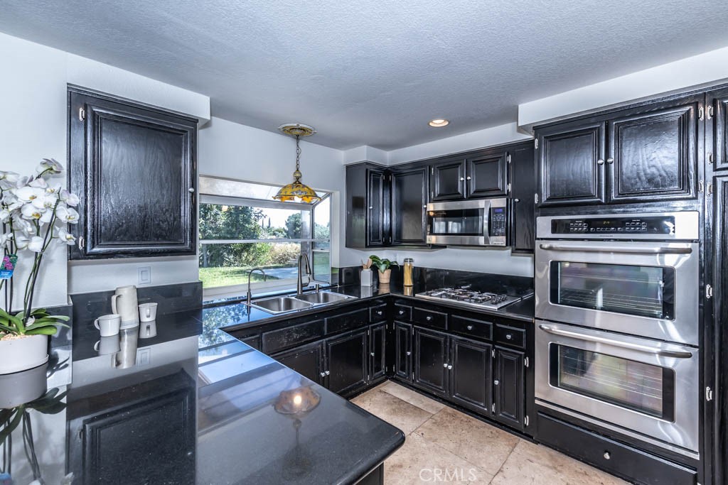1881 Duncan Way Corona, CA 92881 - Photo 36 of 75 a kitchen with stainless steel appliances granite countertop a stove a sink and a microwave