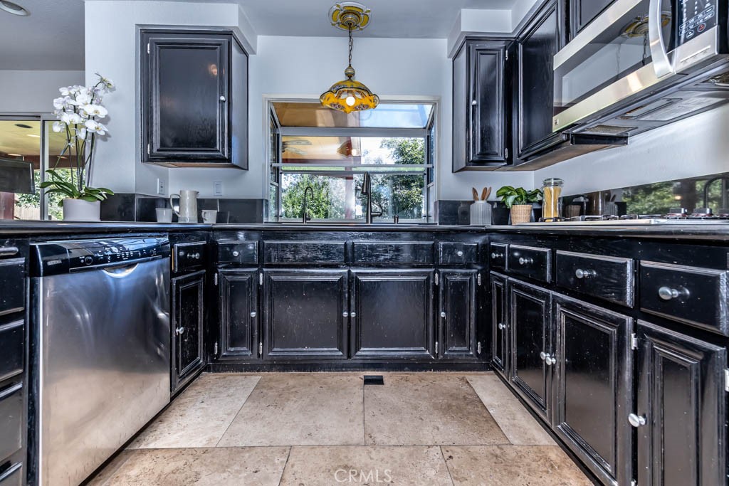 1881 Duncan Way Corona, CA 92881 - Photo 38 of 75 a kitchen with granite countertop a stove a sink and a microwave