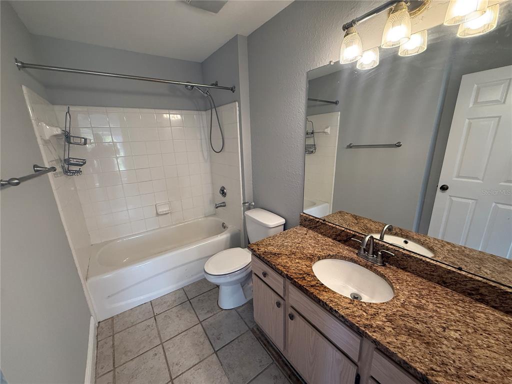 8932 Manor Loop, Unit 205 Lakewood Ranch, FL 34202 - Photo 10 of 15 a bathroom with a granite countertop sink toilet mirror and shower