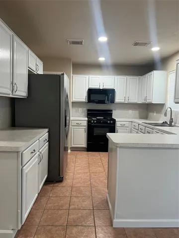 a kitchen with stainless steel appliances granite countertop a refrigerator stove top oven and sink