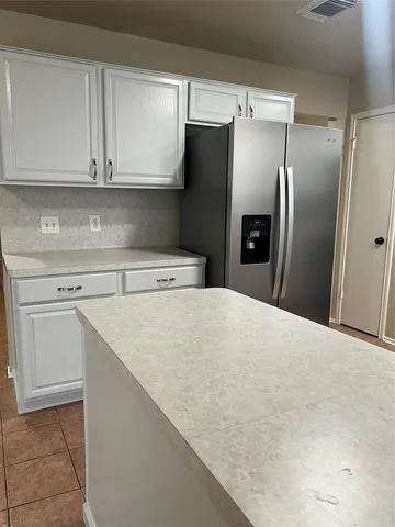 a kitchen with stainless steel appliances a refrigerator and cabinets