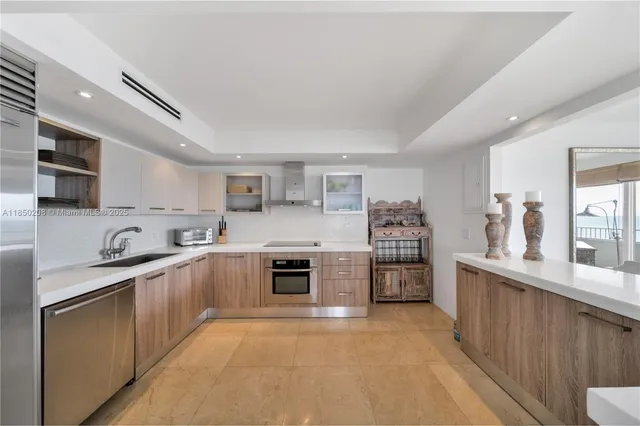 a large white kitchen with stainless steel appliances lots of counter top space