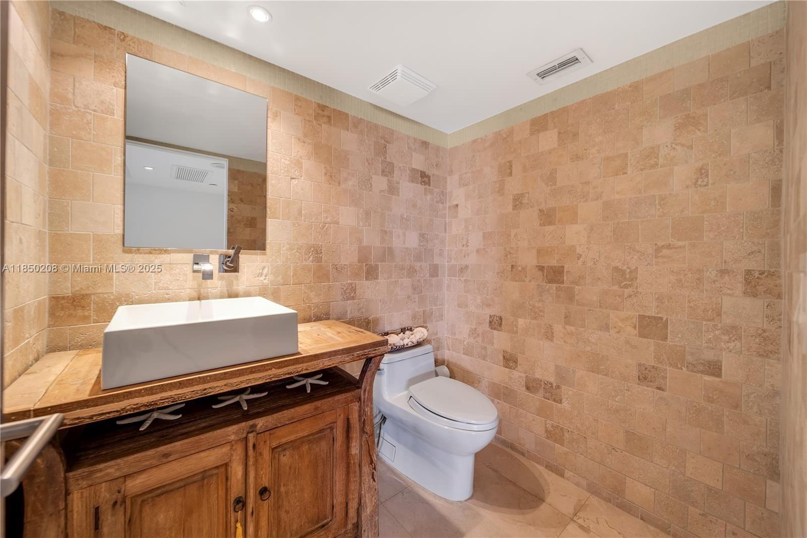 199 Ocean Ln Drive, Unit 901 Key Biscayne, FL 33149 - Photo 21 of 31 a bathroom with a granite countertop sink a toilet and a mirror