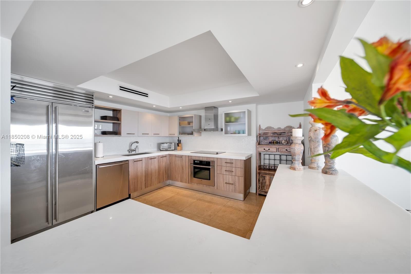 199 Ocean Ln Drive, Unit 901 Key Biscayne, FL 33149 - Photo 9 of 31 a kitchen with stainless steel appliances a stove a refrigerator a sink a microwave a dining table and chairs