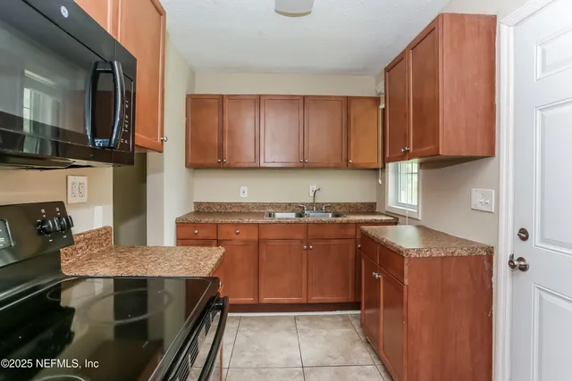 a kitchen with stainless steel appliances granite countertop a stove top oven a sink dishwasher and cabinets with wooden floor