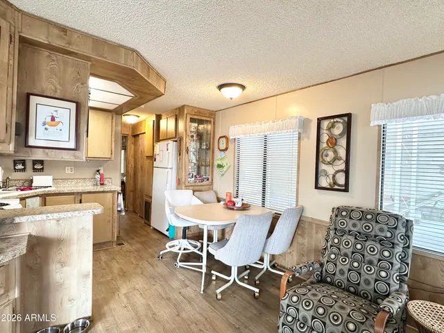 a hallway with painting on the wall and a refrigerator