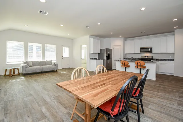 a dining room with furniture and wooden floor