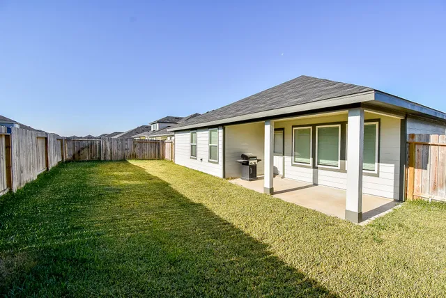 a view of a house with backyard and porch