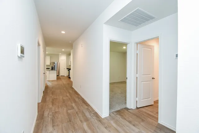 a view of a hallway with wooden floor