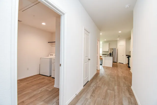 a view of a kitchen with a refrigerator and a stove top oven