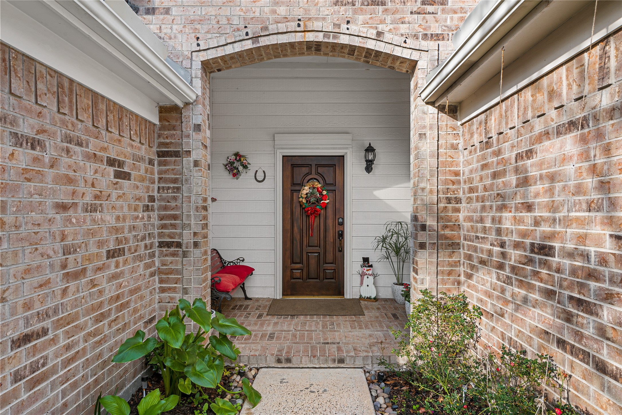 31203 Baker Lake Drive Spring, TX 77386 - Photo 3 of 24 An inviting arched entryway featuring a beautifully paneled solid wood door in a rich dark finish, with ample space to accommodate a seating area for relaxed outdoor enjoyment.