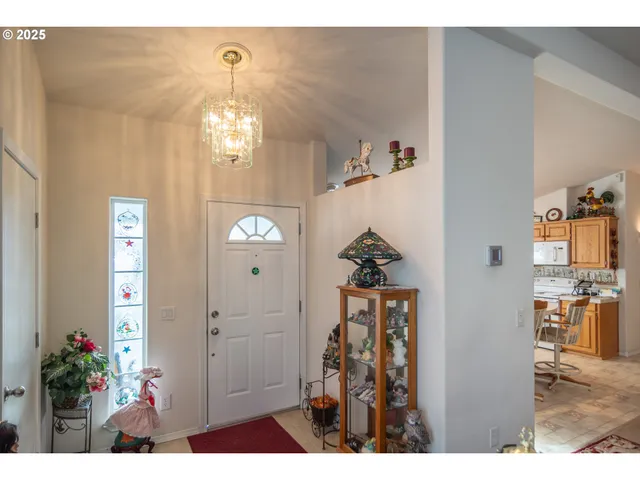 a view of a hallway with wooden floor and chandelier