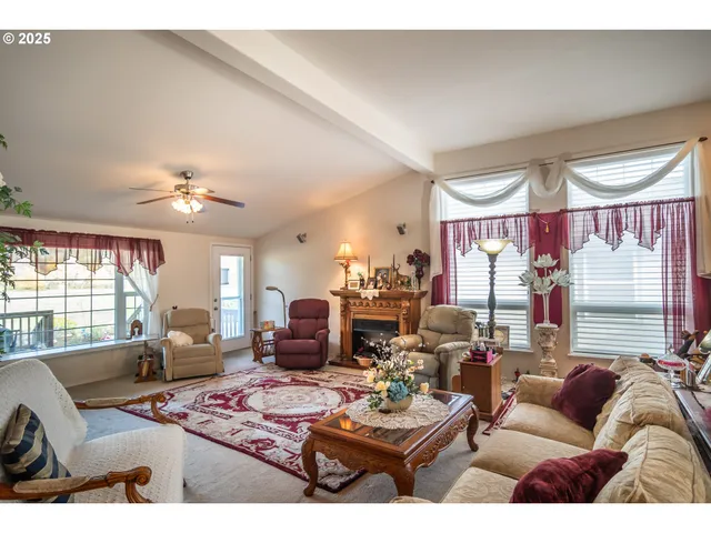 a living room with furniture a large window and a chandelier