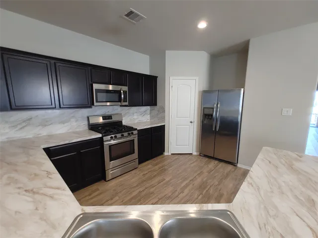 a kitchen with granite countertop stainless steel appliances and a refrigerator