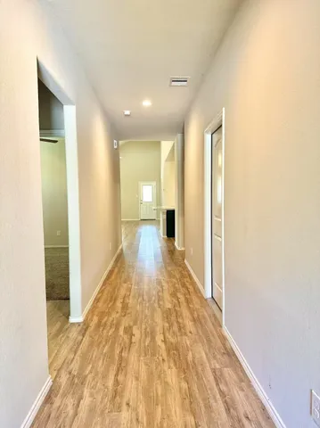 a view of a hallway with wooden floor