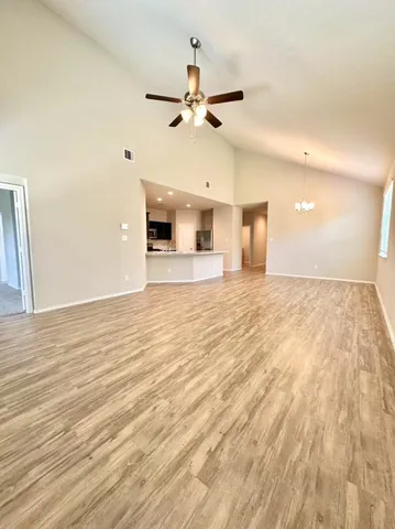 a view of an empty room and kitchen view