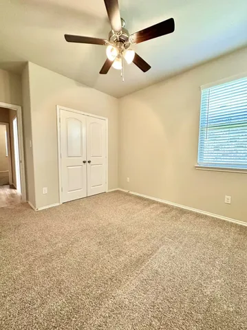 an empty room with windows and fan