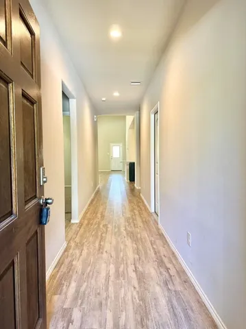 a view of a hallway with wooden floor and staircase