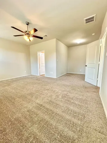en empty room with ceiling fan and window