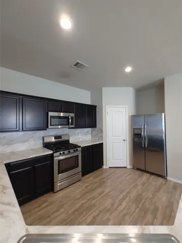 a kitchen with stainless steel appliances granite countertop a stove a refrigerator and a sink