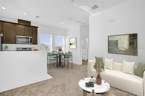 a living room with furniture a dining table and kitchen view