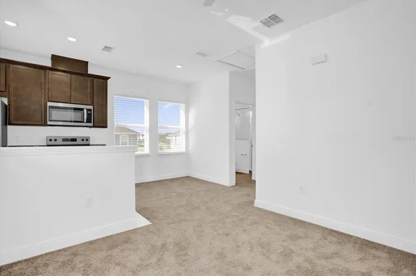 a kitchen with kitchen island a stove a microwave a sink and a refrigerator