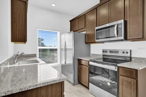 a kitchen with stainless steel appliances granite countertop a stove and a microwave