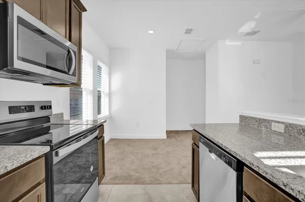 a kitchen with stainless steel appliances granite countertop a sink and a microwave