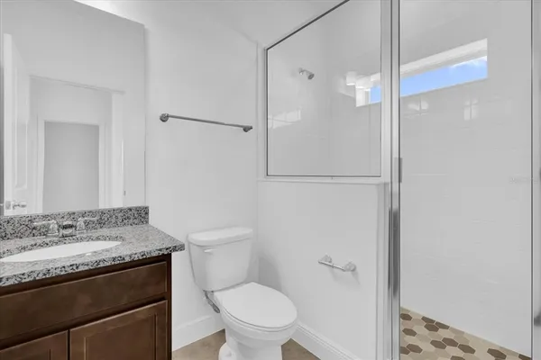 a bathroom with a granite countertop sink toilet and shower