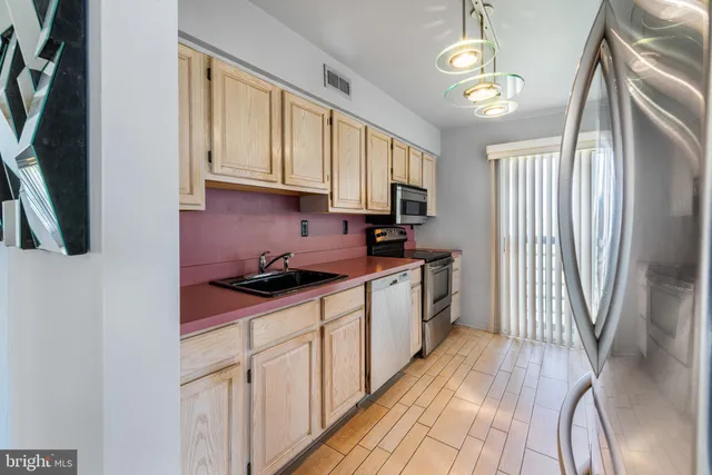 a kitchen with cabinets appliances and a window
