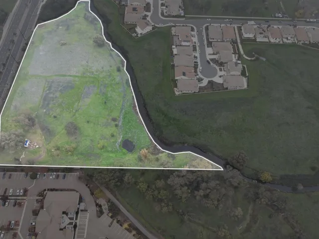 an aerial view of a golf course with a lake view