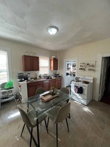 a living room with stainless steel appliances furniture a flat screen tv and a window