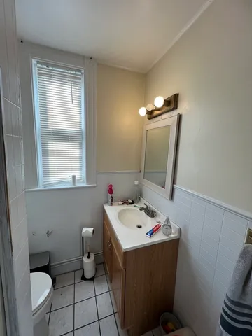 a bathroom with a sink vanity mirror and toilet