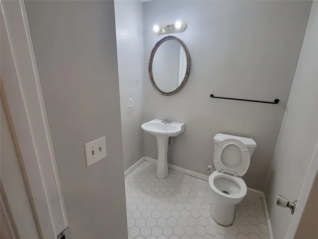 a bathroom with a toilet sink and a mirror